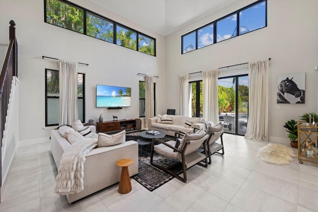 living room with a towering ceiling and light tile patterned flooring