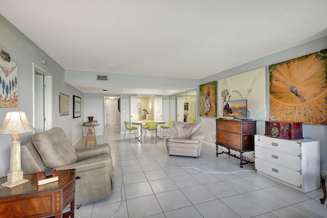 tiled living room featuring a textured ceiling