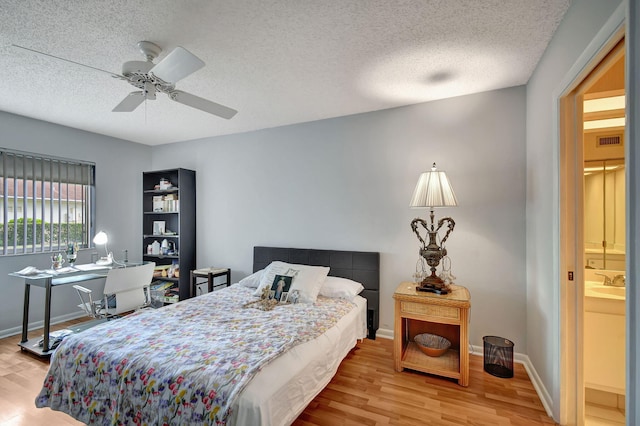 bedroom featuring ceiling fan, light hardwood / wood-style flooring, and a textured ceiling