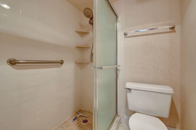 bathroom with a shower with door, tile patterned flooring, and toilet