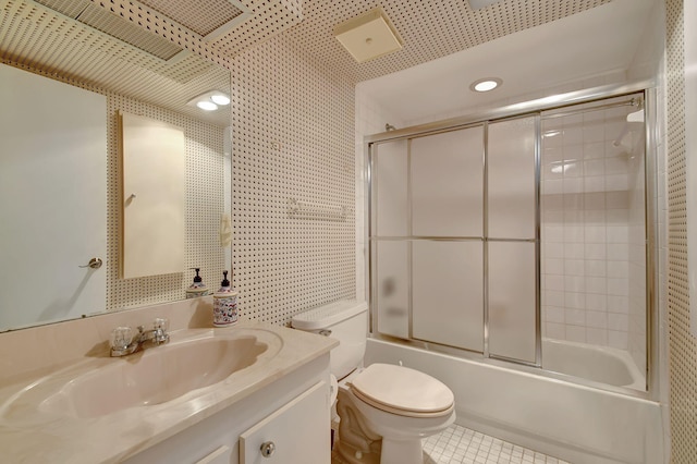 full bathroom with tile patterned flooring, vanity, bath / shower combo with glass door, and toilet