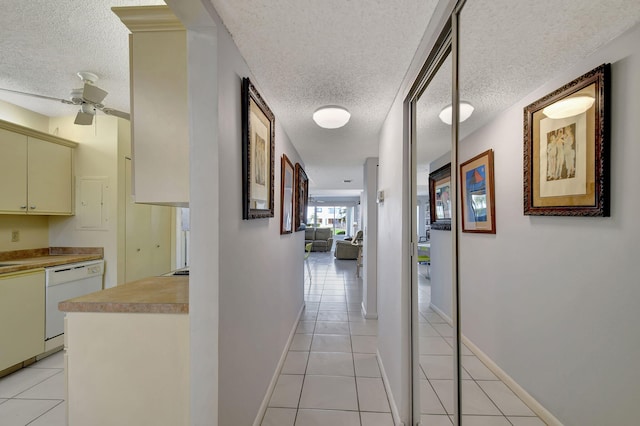 hall with light tile patterned flooring and a textured ceiling