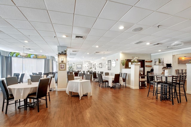 dining room with a paneled ceiling and hardwood / wood-style flooring