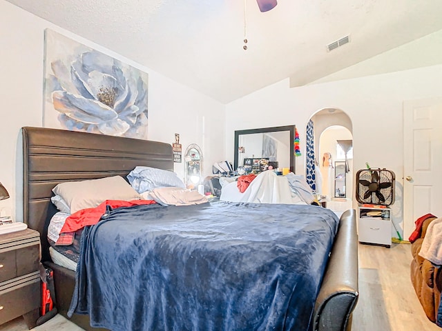 bedroom with light hardwood / wood-style floors, ceiling fan, and lofted ceiling