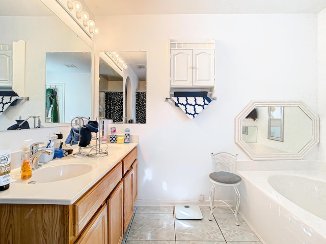 bathroom featuring tile patterned flooring, vanity, and a tub to relax in