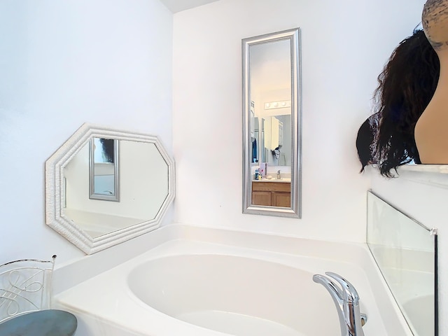 bathroom with a washtub and vanity