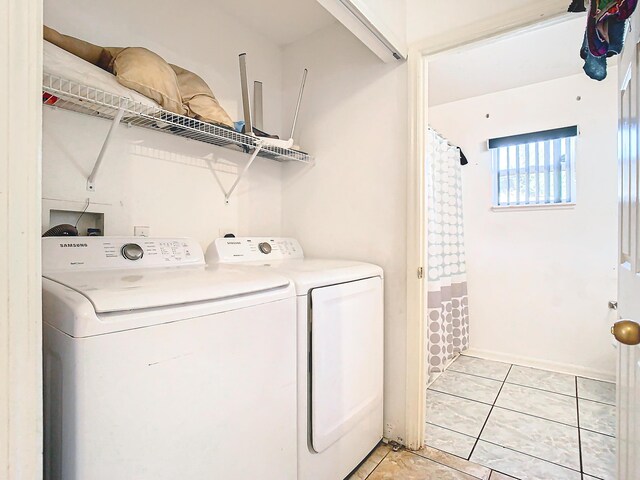 laundry room with washer and dryer and light tile patterned floors