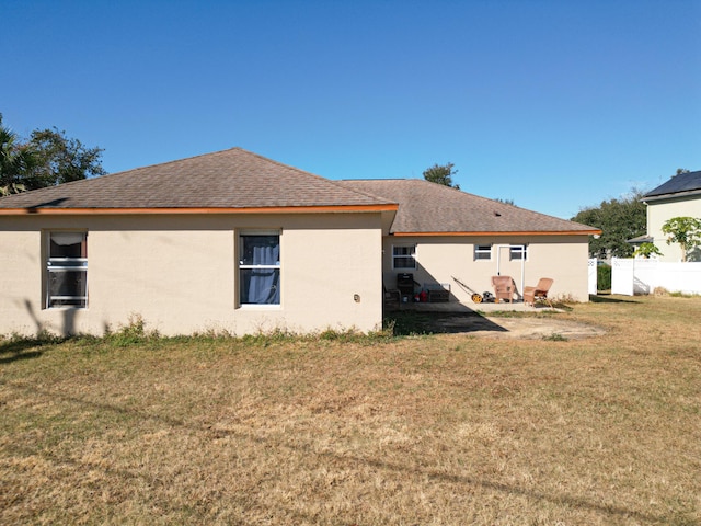 rear view of house featuring a yard