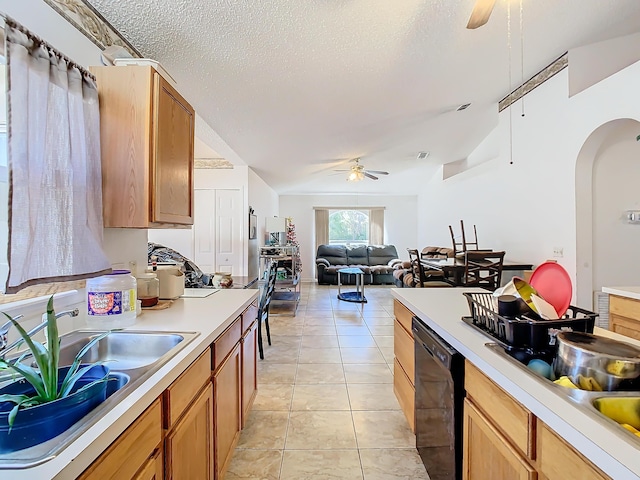 kitchen with dishwasher, sink, ceiling fan, light tile patterned floors, and a textured ceiling