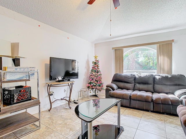 living room featuring ceiling fan, light tile patterned flooring, and a textured ceiling