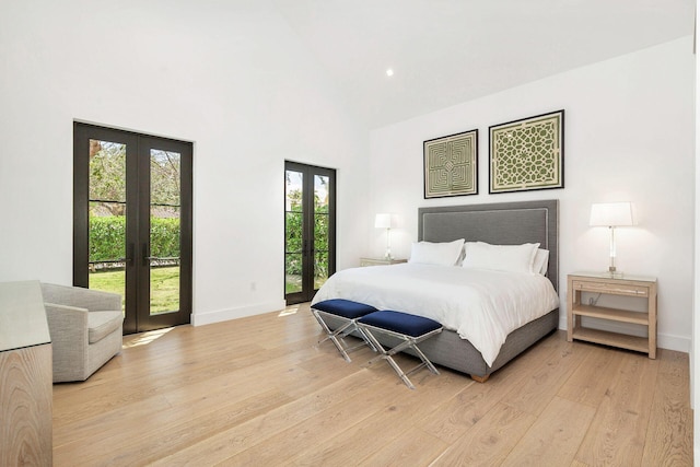 bedroom featuring access to outside, french doors, high vaulted ceiling, and light hardwood / wood-style floors