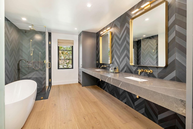 bathroom featuring plus walk in shower, hardwood / wood-style floors, and vanity