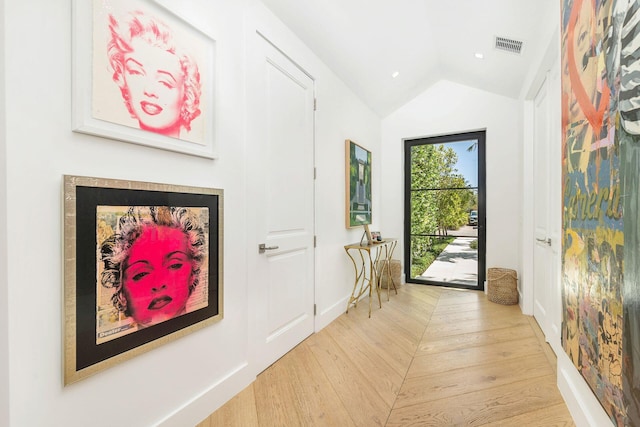 doorway featuring light hardwood / wood-style floors and vaulted ceiling