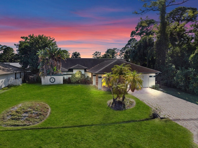 single story home featuring a lawn and a garage