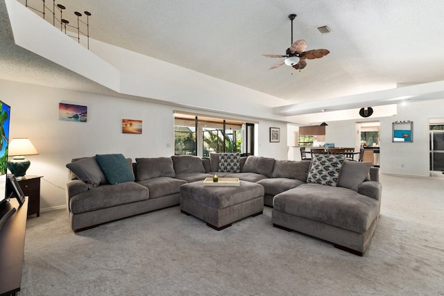 carpeted living room with ceiling fan, lofted ceiling, and a textured ceiling