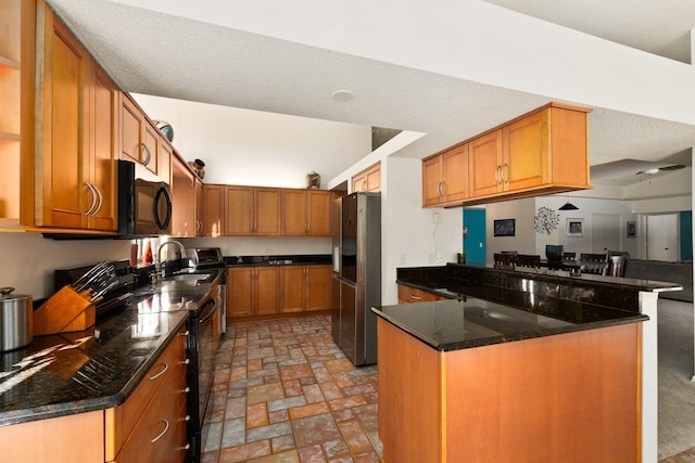 kitchen with black appliances, sink, dark stone countertops, a textured ceiling, and kitchen peninsula