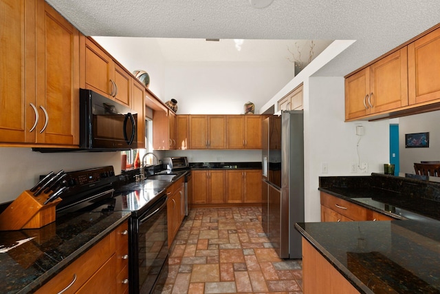 kitchen with dark stone countertops, sink, black appliances, and a textured ceiling