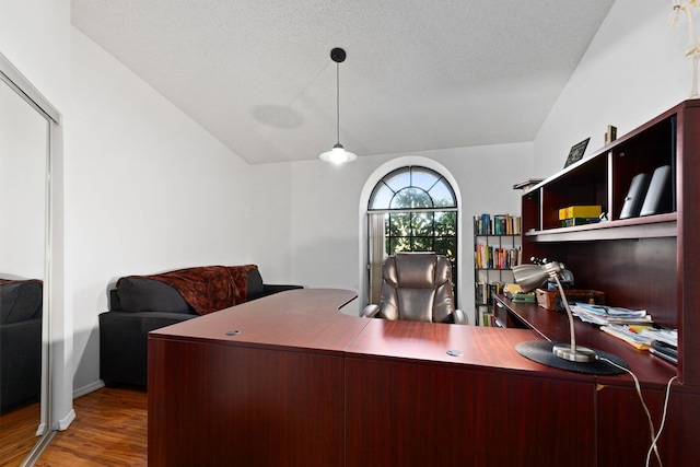 office area featuring a textured ceiling, hardwood / wood-style floors, and vaulted ceiling