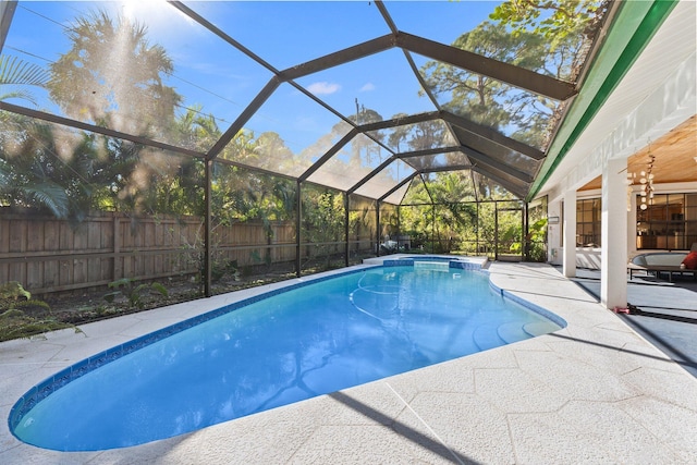 view of pool with glass enclosure and a patio