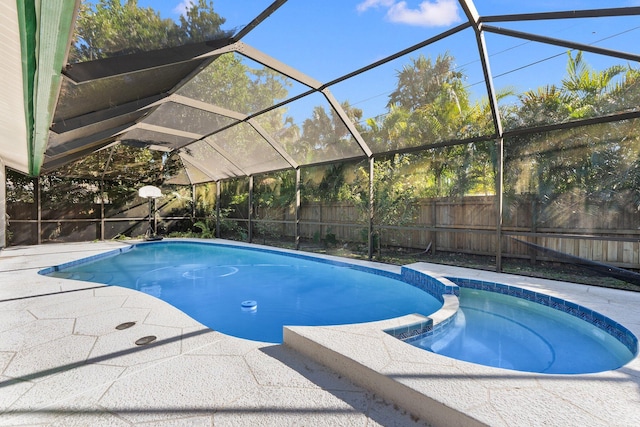 view of swimming pool with glass enclosure and a patio