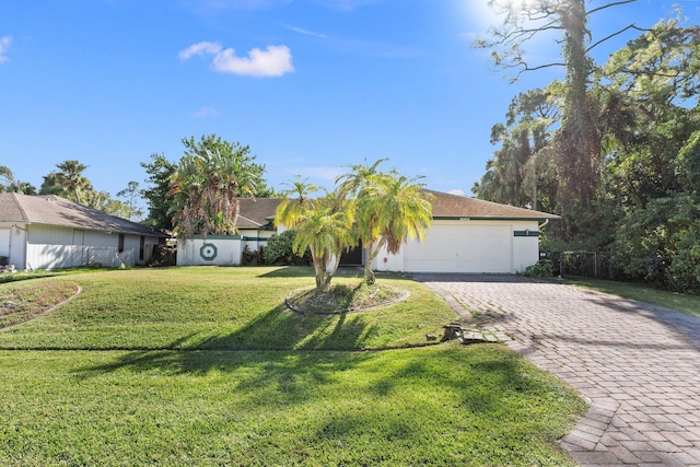 ranch-style home featuring a front lawn and a garage