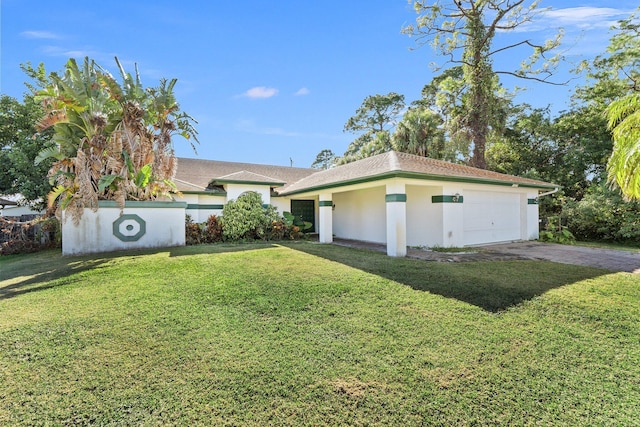 view of front of home with a front yard and a garage