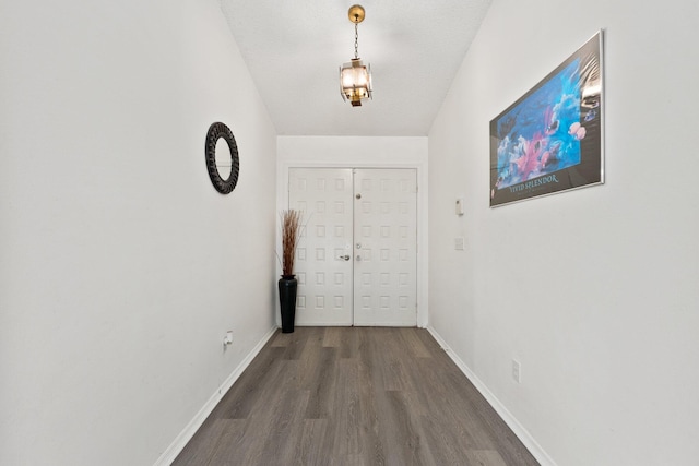 doorway featuring dark wood-type flooring and a textured ceiling