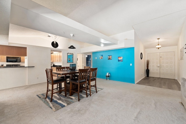 carpeted dining room featuring lofted ceiling