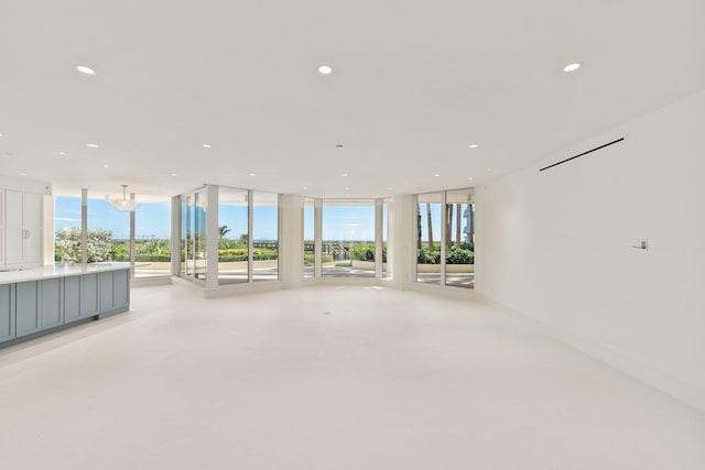 unfurnished living room with floor to ceiling windows and a chandelier