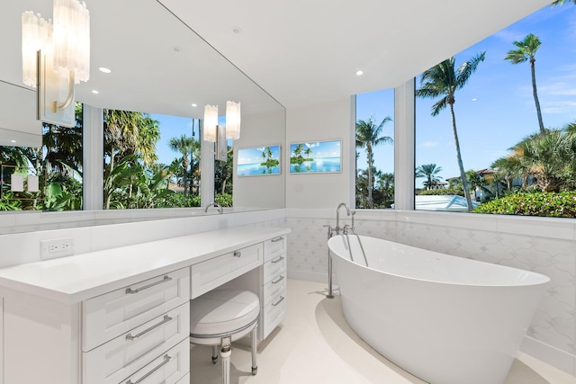 bathroom with vanity, a bath, and tile walls