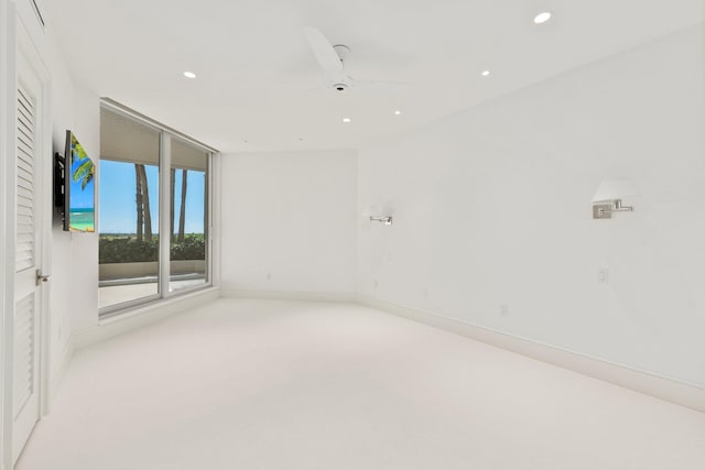 unfurnished room with light colored carpet and ceiling fan