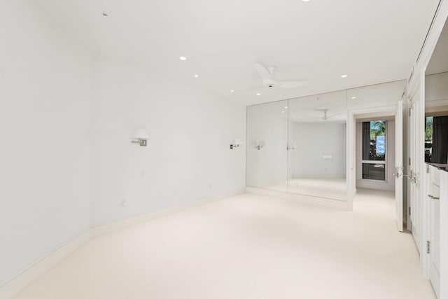 unfurnished bedroom featuring two closets, ceiling fan, and light colored carpet