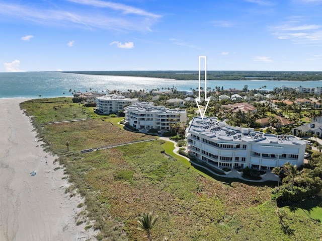 birds eye view of property with a water view and a beach view