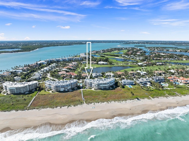 drone / aerial view featuring a beach view and a water view