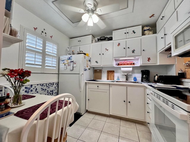 kitchen featuring white appliances, white cabinetry, ceiling fan, and light tile patterned flooring