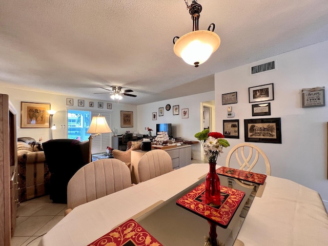 dining room with ceiling fan, light tile patterned floors, and a textured ceiling