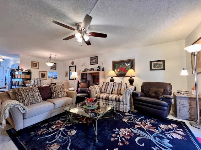 living room with ceiling fan, tile patterned flooring, and a textured ceiling