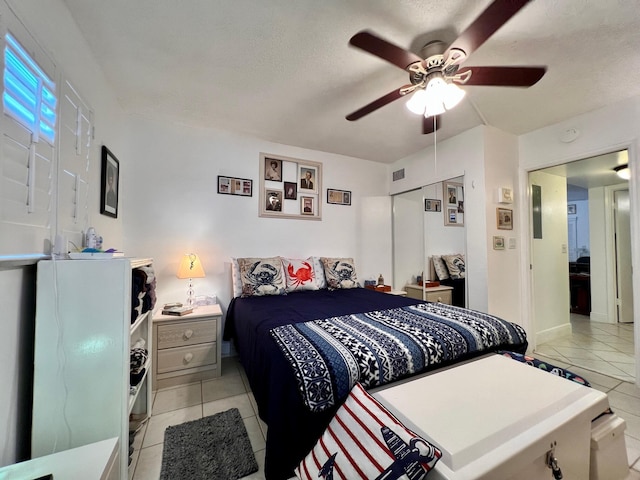 tiled bedroom featuring a textured ceiling, a closet, and ceiling fan