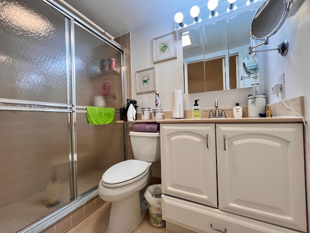 bathroom with tile patterned flooring, vanity, toilet, and walk in shower