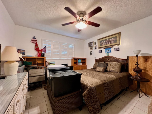 tiled bedroom featuring a textured ceiling and ceiling fan