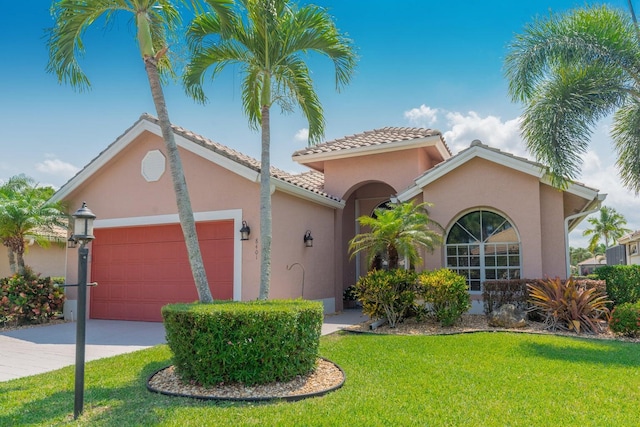 mediterranean / spanish home featuring a garage and a front lawn