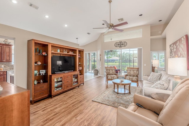 living room with ceiling fan, light hardwood / wood-style flooring, and high vaulted ceiling