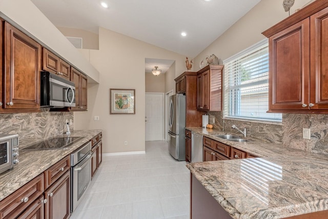 kitchen with appliances with stainless steel finishes, backsplash, light stone counters, vaulted ceiling, and sink