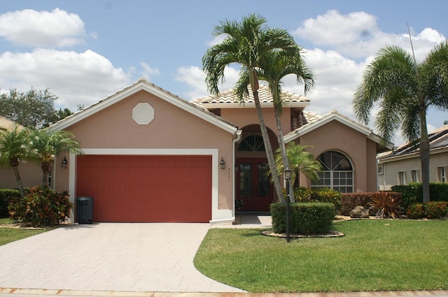 view of front facade with a garage, a front yard, and french doors