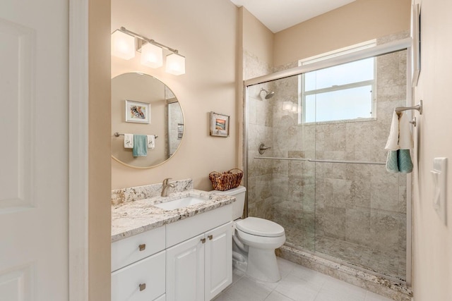 bathroom with tile patterned floors, vanity, toilet, and a shower with shower door