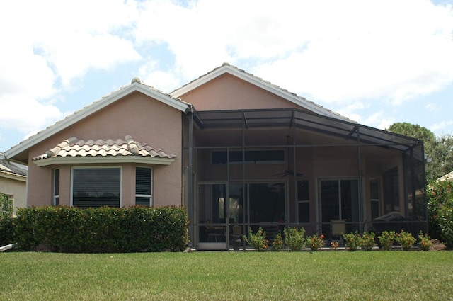 back of house with a lanai and a yard