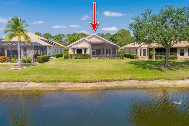 back of house with a yard and a water view