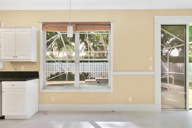 unfurnished dining area featuring light tile patterned floors and crown molding