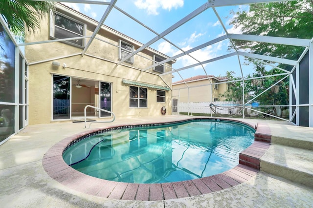 view of swimming pool featuring glass enclosure and a patio area