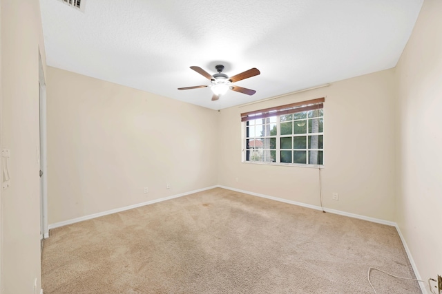 carpeted empty room featuring a textured ceiling and ceiling fan